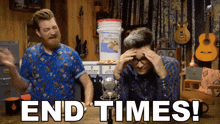 two men are sitting at a table with the words end times written in white