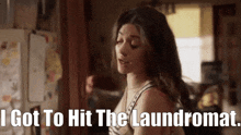 a woman is standing in a room with the words " i got to hit the laundromat " above her