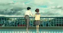 a man and a woman are standing on a balcony looking at the city