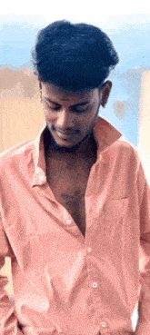 a man in a pink shirt has a tattoo on his chest that says ' shiva '