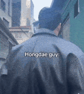 a man wearing a black leather jacket with the words hongdae guy written on the back