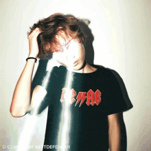a person wearing a black t-shirt that says ac dc