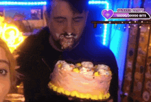 a man is holding a cake with a sticker party badge above him