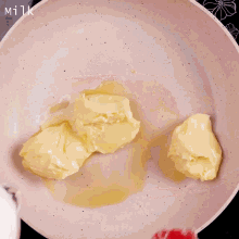 a red spoon is in a pot of yellow liquid
