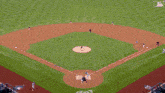 an aerial view of a baseball field with an ad for geico in the background