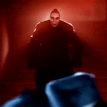 a man with a mask on his face stands in the dark
