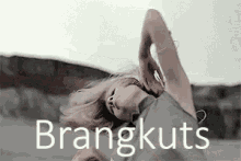 a woman is dancing in front of a sign that says ' braangkuts '