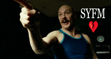 a man in a blue tank top is pointing at something with syfm written on the bottom