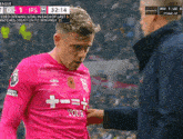 a soccer player wearing a pink shirt that says tour