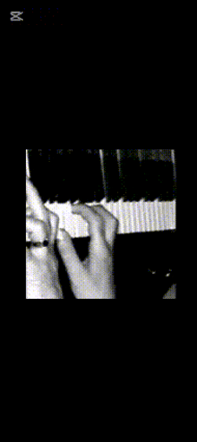 a black and white photo of a person playing a piano with arabic writing on the bottom