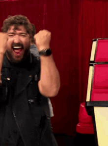 a man with his fist in the air is wearing a wrist watch