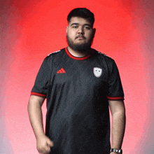 a man with a beard wearing an adidas shirt