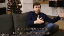 a man is sitting on a couch and says i don 't know that i 've really been paying attention