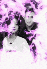 a man and a woman are standing next to each other in a black and white photo surrounded by purple flames .
