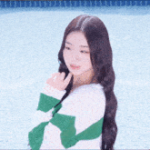 a woman wearing a green and white striped sweater is standing in front of a pool