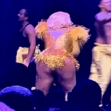 a woman in a gold and orange costume is dancing on a stage