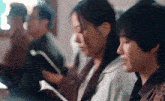 a group of people are sitting at a table in a classroom reading books .
