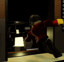 a lego man in a red jacket is holding a gun in a dark room