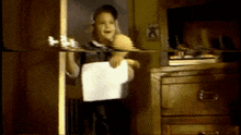a young boy is holding a piece of paper in his hand
