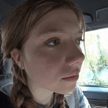 a close up of a woman 's face with a braid