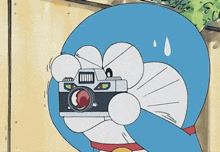 doraemon is holding a camera in his hand
