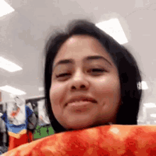 a woman is making a funny face in a store while holding a pillow .