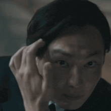 a woman in a suit and tie is making a funny face with her hand to her face .