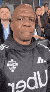 a man taking a selfie in a stadium while wearing a jersey with the word omo3 on it