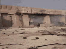 a man in a yellow shirt and black pants is running in the sand