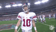 a football player with the number 10 on his jersey stands on the field