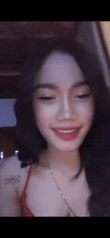 a close up of a woman 's face with a red top on