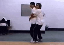 a man and a woman are dancing in a room .