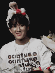 a young man wearing glasses and a headband with bunny ears is smiling