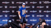 a man in a blue shirt is standing in front of a wall that says backlash