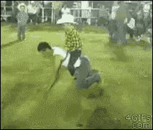 a man in a cowboy hat is riding on the back of another man in a field .