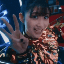 a close up of a woman giving a peace sign with her hand