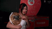 a woman in a white dress is holding a wrestling belt in front of a sign that says oklahoma