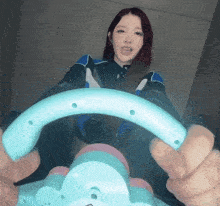 a woman with red hair is holding a blue steering wheel in her hands