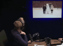 a man wearing headphones watches a hockey game on a screen that says courtesy white bear alliance