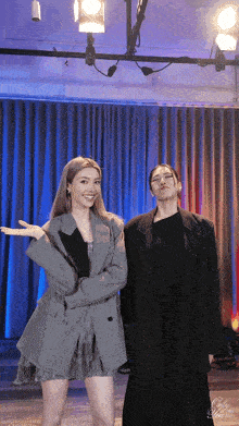 two women standing next to each other in front of a blue curtain with the word only on it