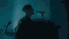 a man is playing drums in a dark room