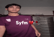 a young man wearing a purple shirt with syfm on it