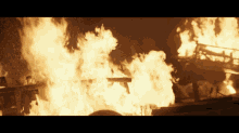 a man is standing in front of a huge fire