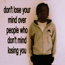 a man stands in front of a sign that says do n't lose your mind over people who don 't mind