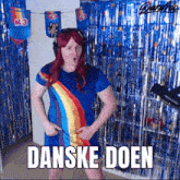 a woman in a rainbow dress stands in front of a blue curtain that says " danske doen "