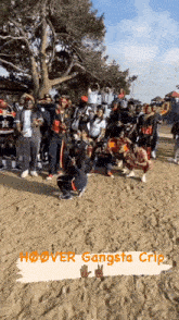 a group of people standing on a sandy beach with the words hoover gangsta grip on the bottom right