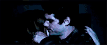 a man and a woman are hugging and kissing in the dark .