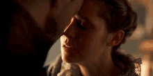 a man and a woman are kissing with their eyes closed in a dark room .