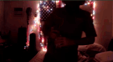 a person standing in front of an american flag with lights on it