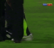 a soccer player is being helped on the field by a person with a sign that says 0-0